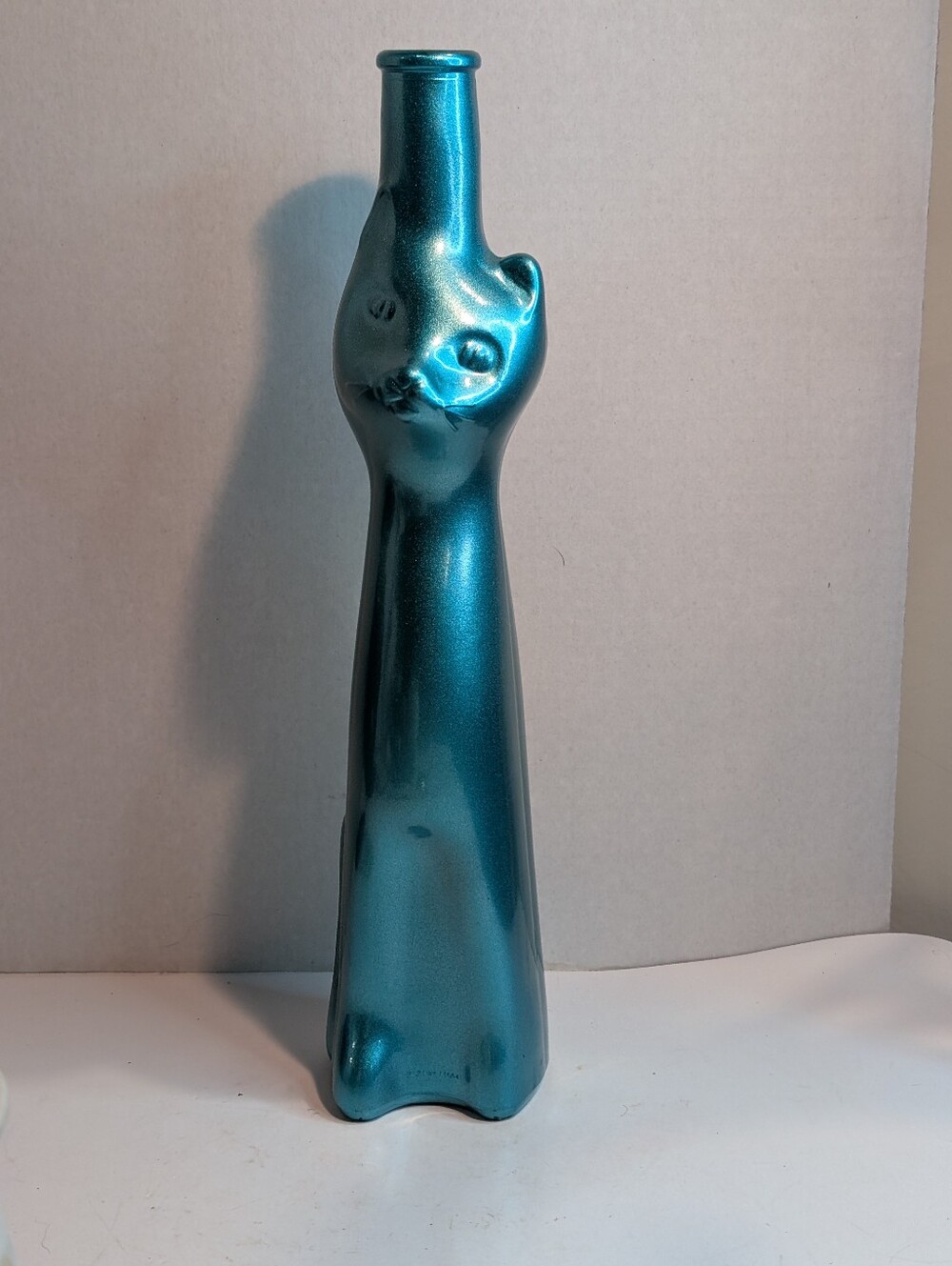 A metallic teal / turquoise Moselland Riesling Cat Bottle, a whimsical